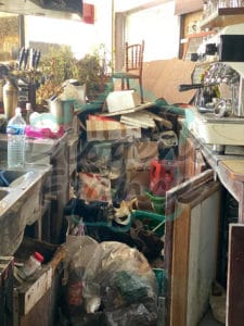 Nettoyage d'un comptoir d’un ancien bar rempli de déchets